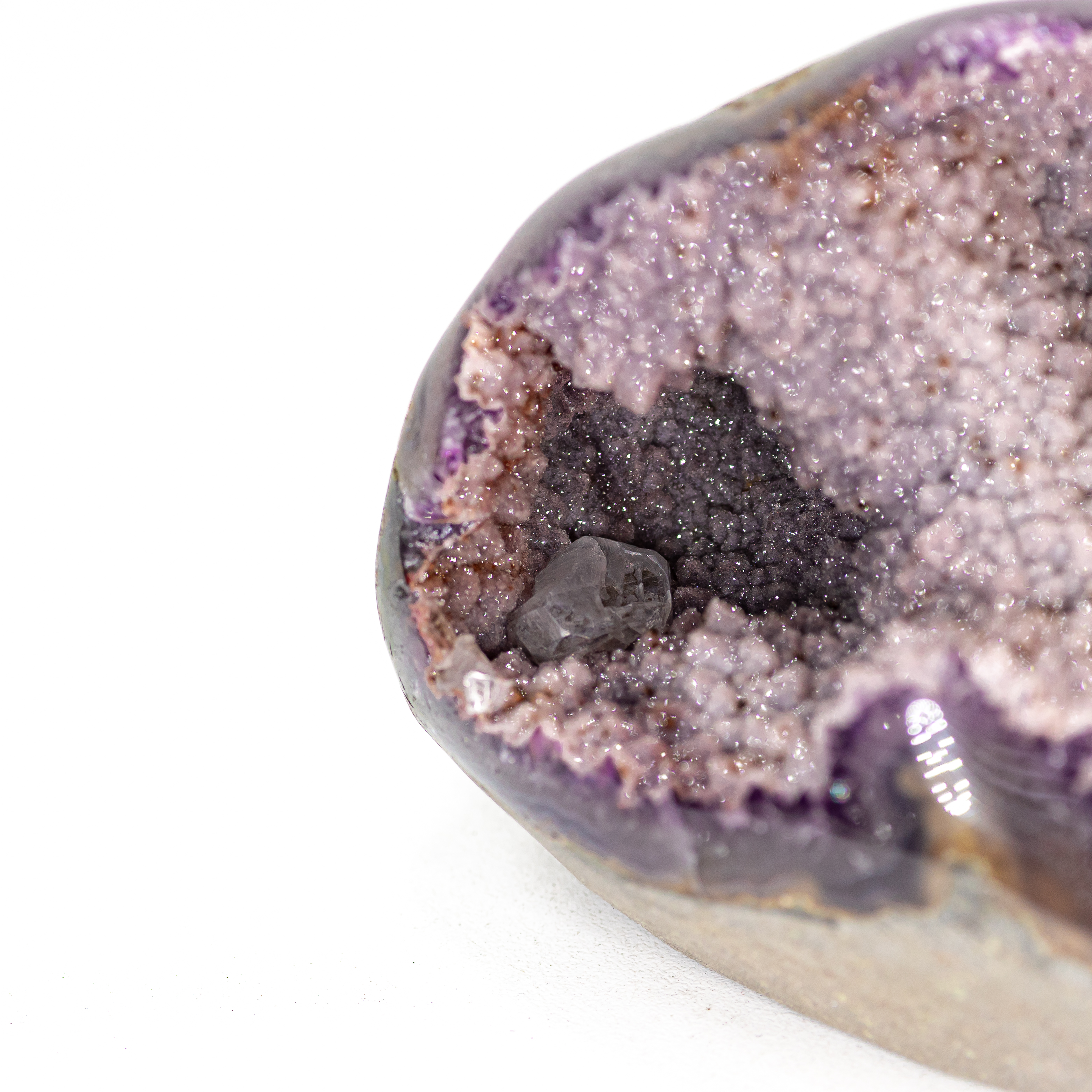 Amethyst quartz geode mounted on a small stand, showing pale and deep purple crystal points.