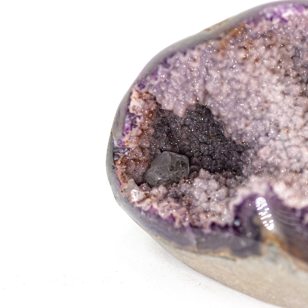 Amethyst quartz geode mounted on a small stand, showing pale and deep purple crystal points.