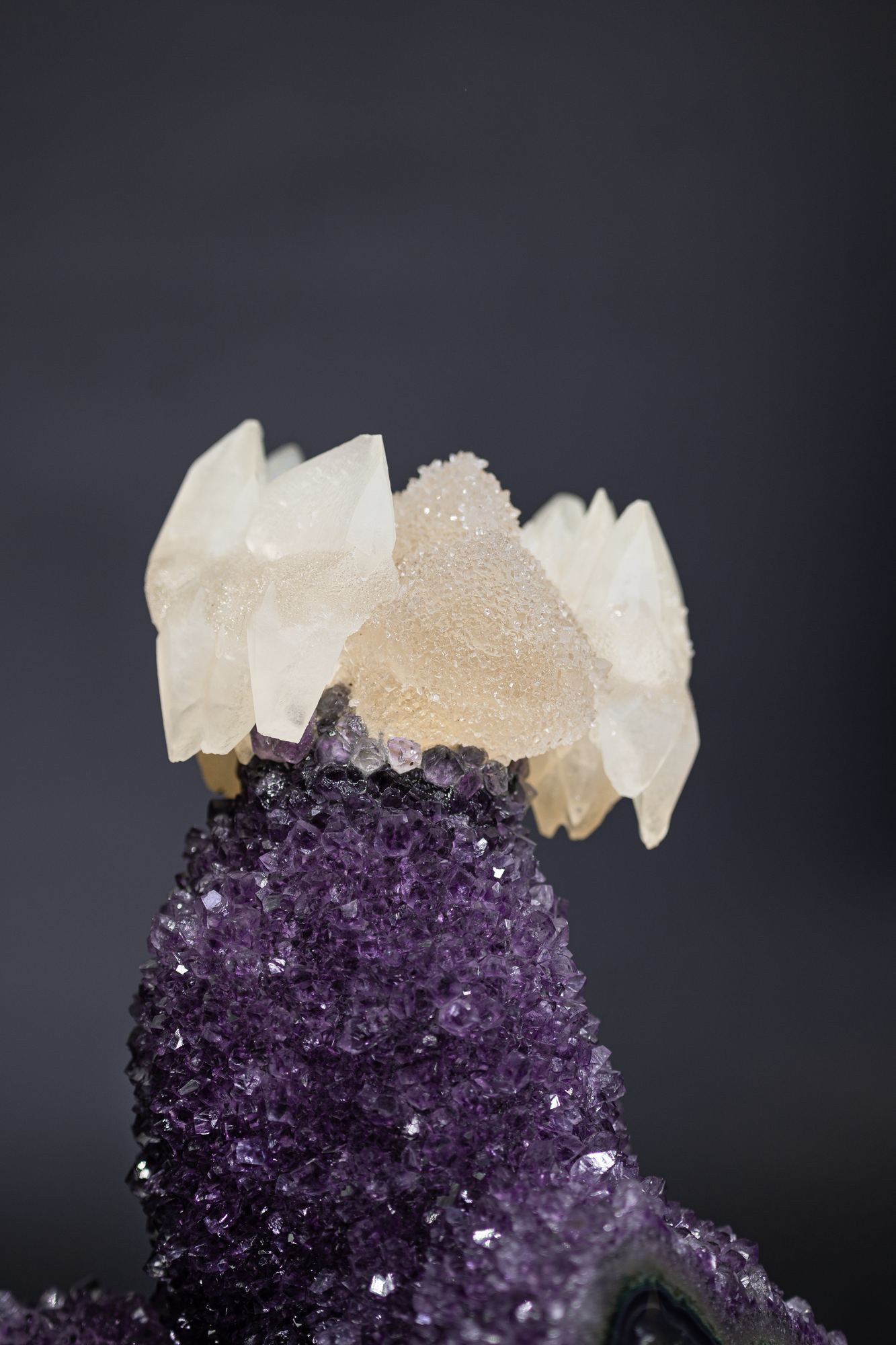 Deep purple amethyst crystal cluster crowned with cream-coloured calcite points.